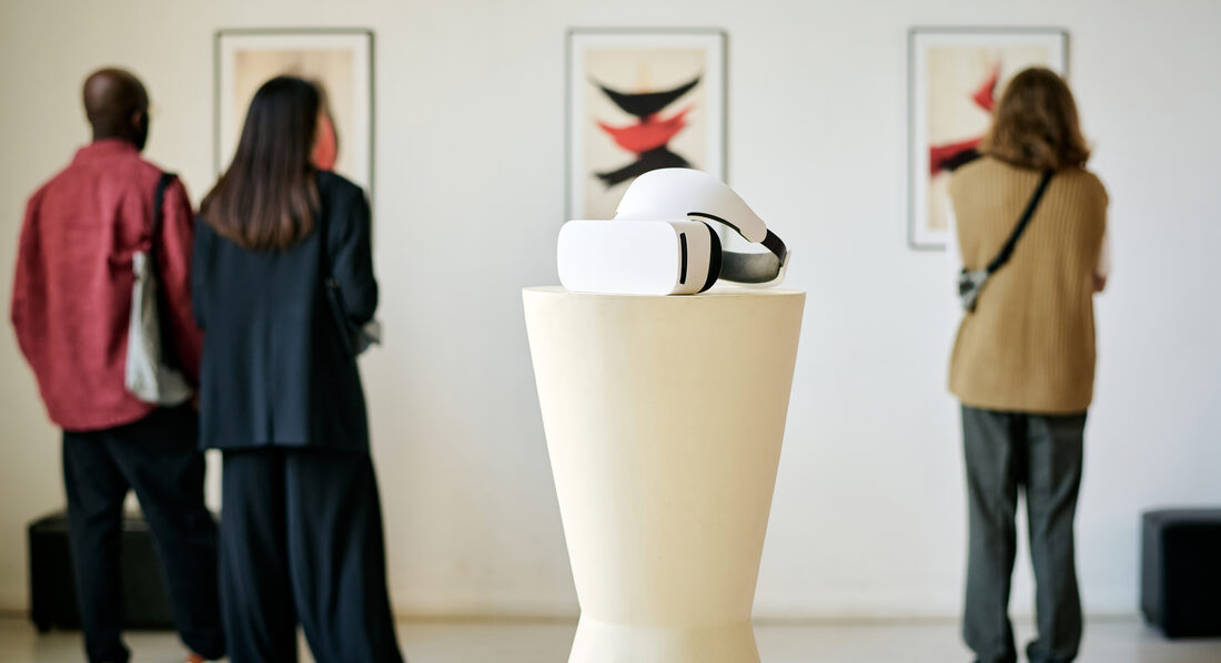 Visitors walking through a softly lit museum gallery