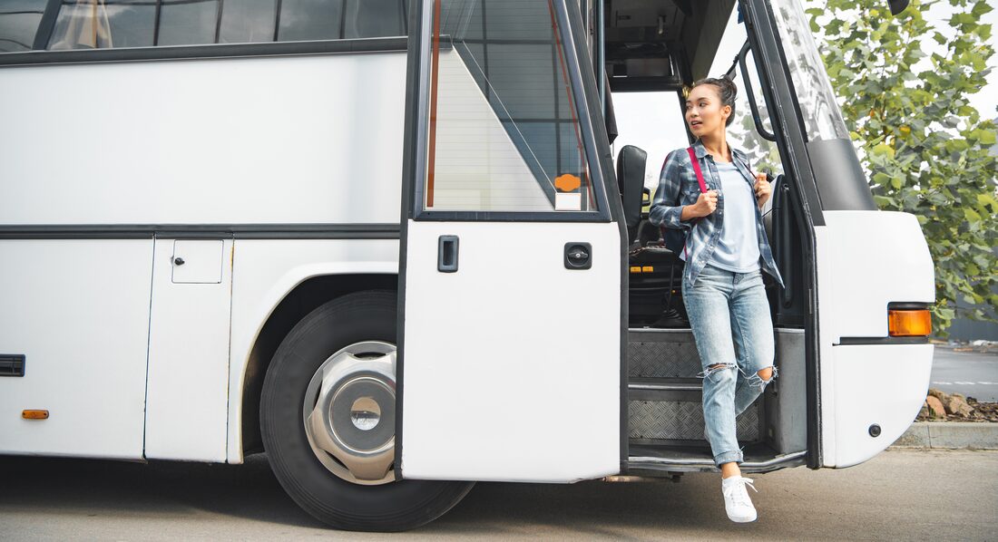 A rider stepping off a bus at a stop